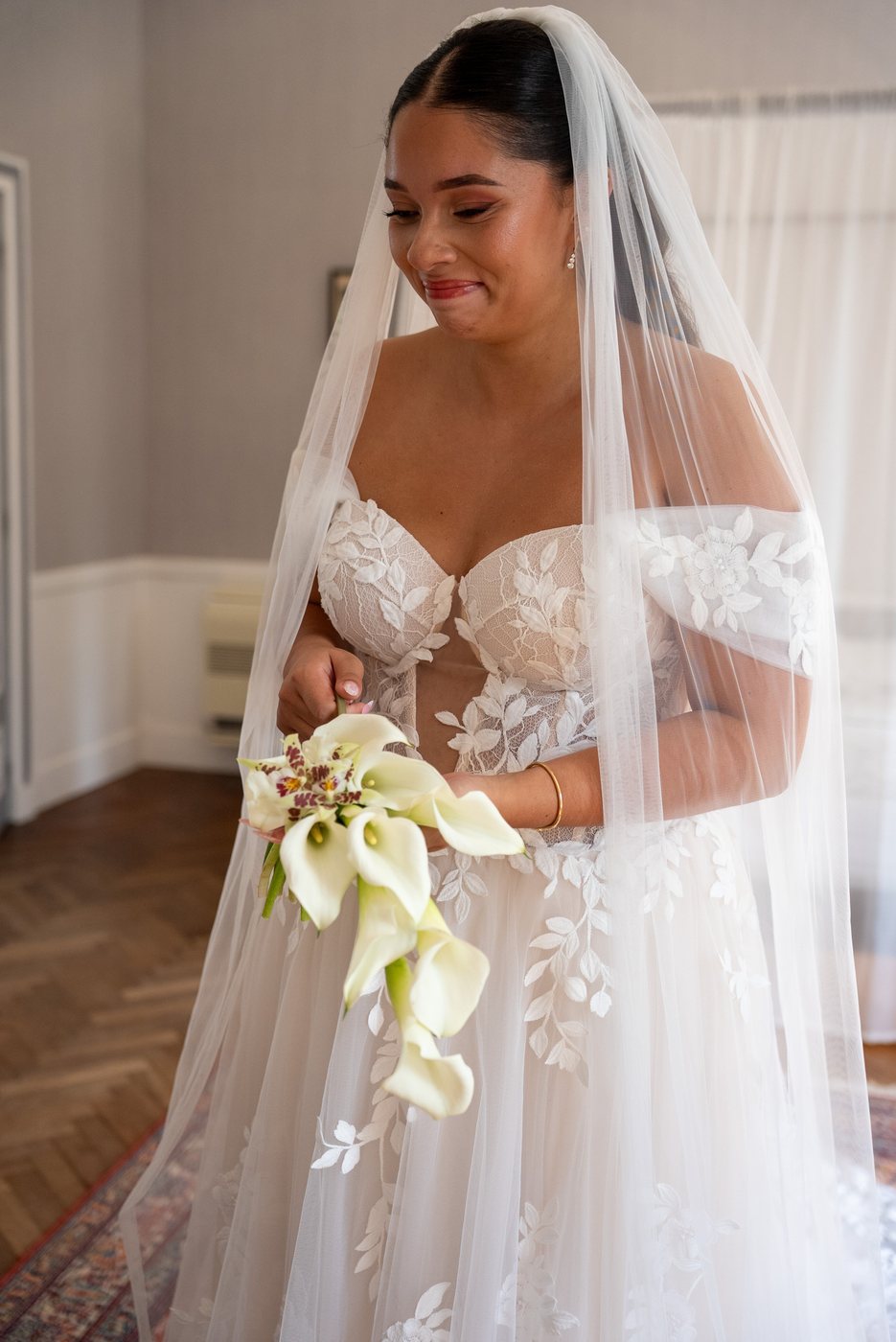 Bride with veil holding a white calla bouquet
