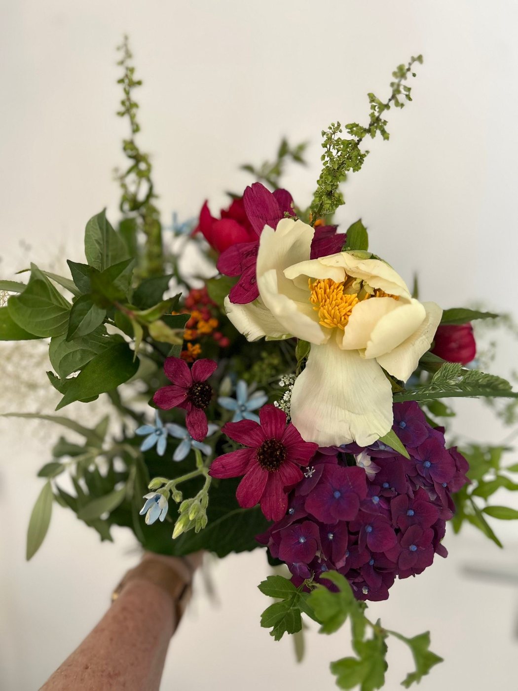 Country-style bouquet with peony and plum blooms