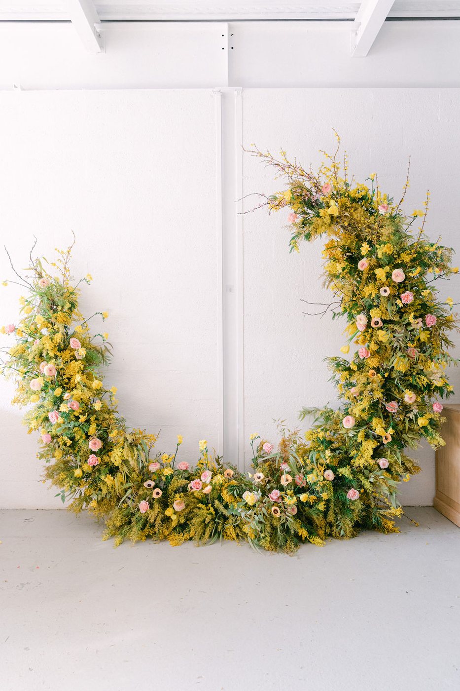 Crescent floral arch in yellow and pastel tones