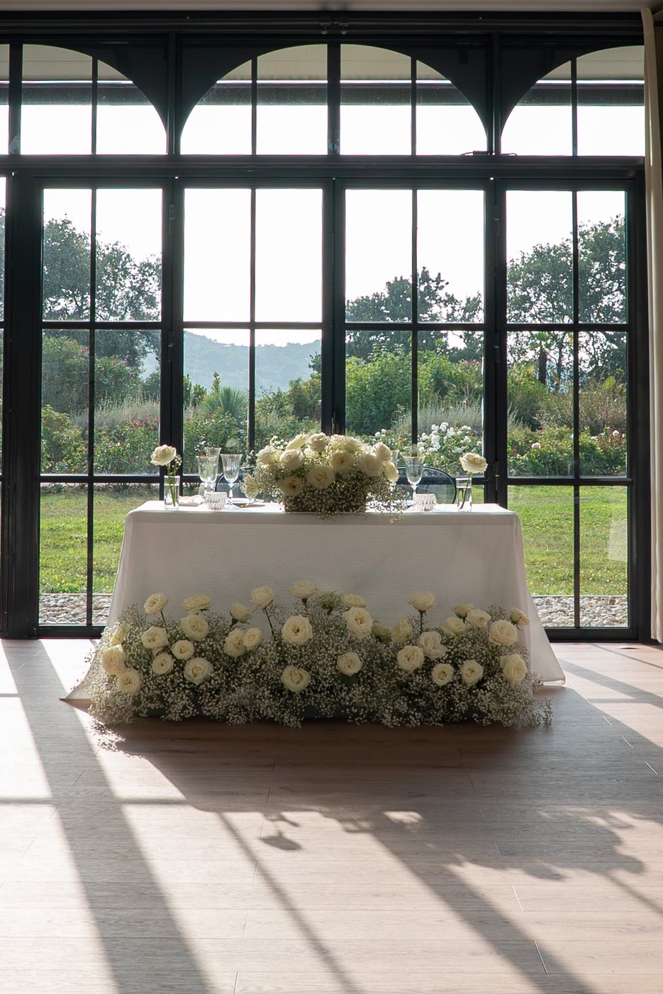 Sweetheart table dressed with white flowers