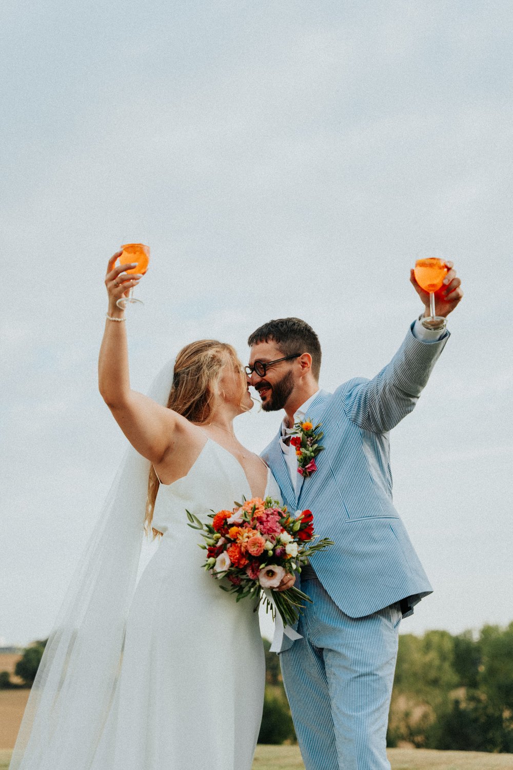 Newlyweds toasting with a colourful bouquet, wedding near Toulouse